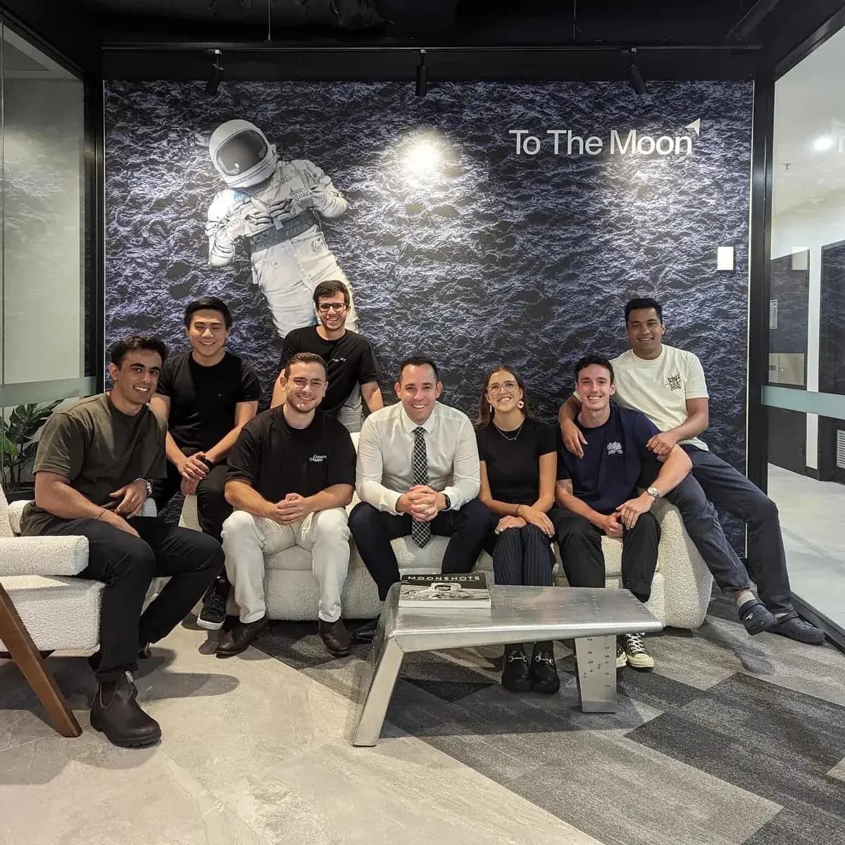 The Moonward team together in front of the To The Moon wall in the Brisbane office